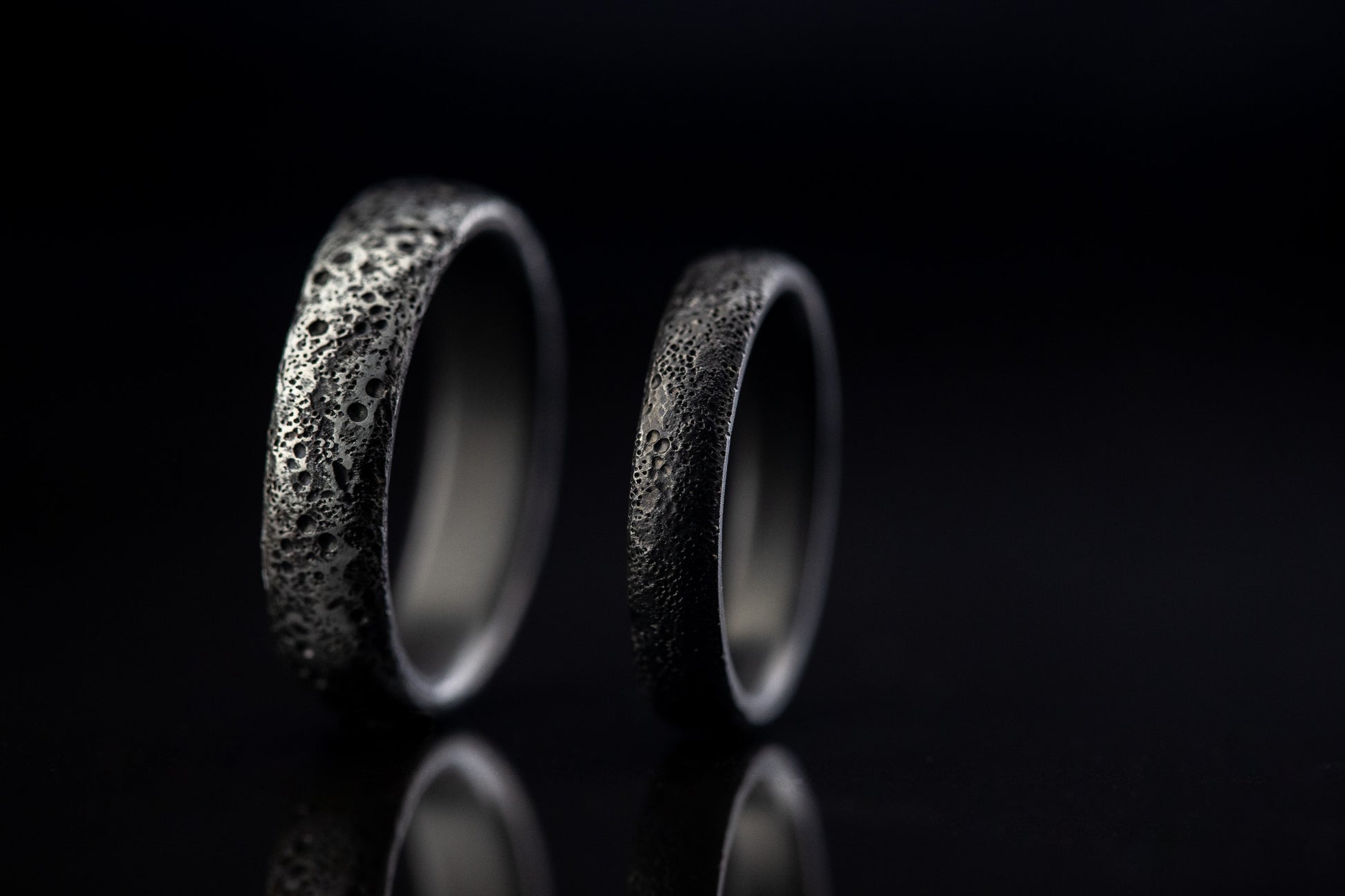Juodi titano žiedai su lavos tekstūra
